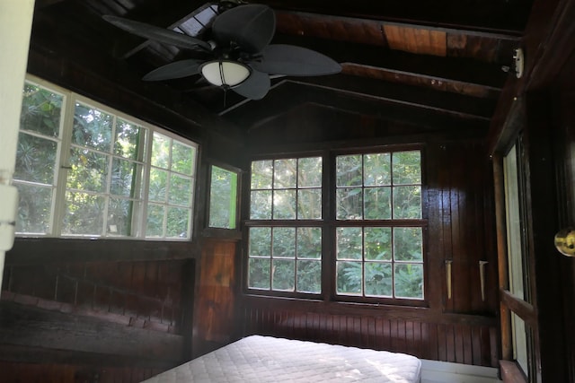 sunroom featuring lofted ceiling with beams, ceiling fan, and wooden ceiling