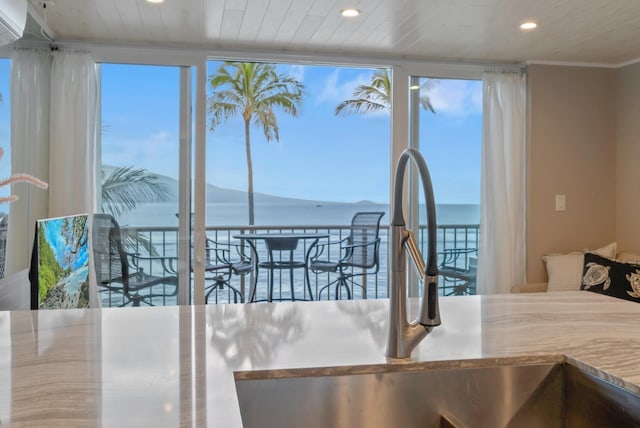 interior space with crown molding, recessed lighting, a water view, and a healthy amount of sunlight