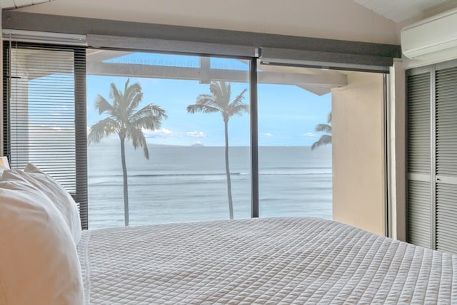 bedroom featuring an AC wall unit and a water view