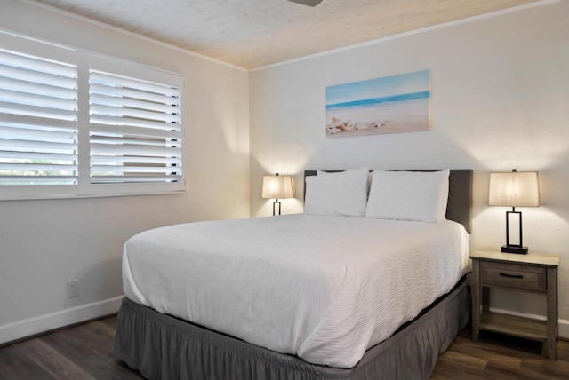bedroom with baseboards, wood finished floors, and crown molding
