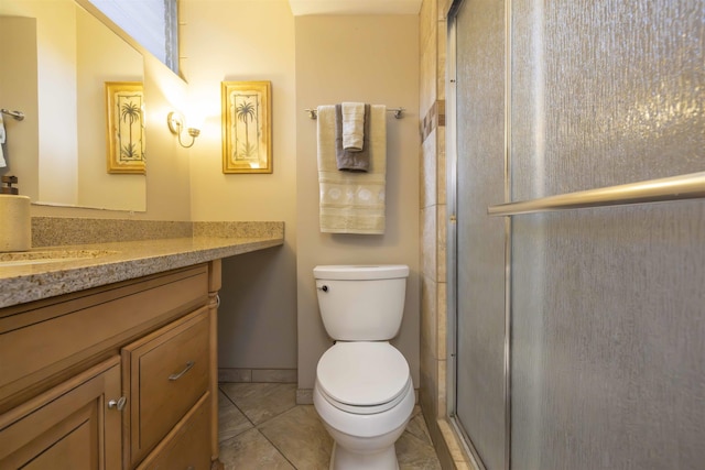 bathroom featuring toilet, a shower with door, vanity, and tile patterned flooring