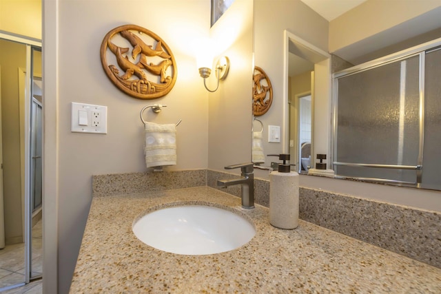 bathroom featuring a shower with door and vanity