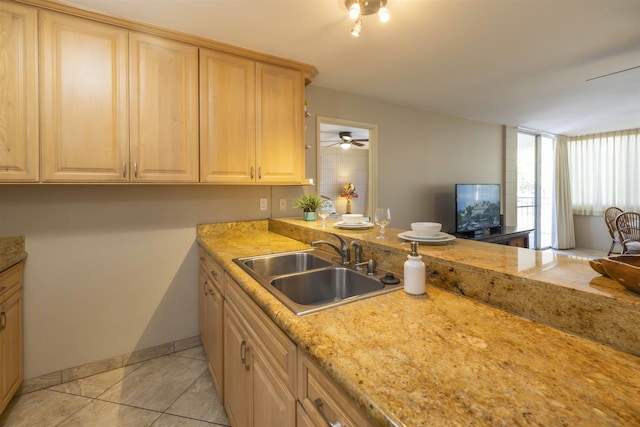 kitchen featuring sink, light tile patterned floors, light stone countertops, and light brown cabinets