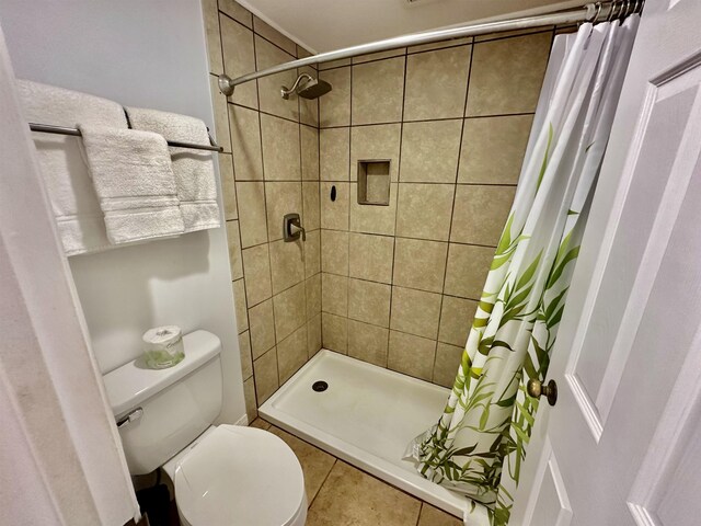 bathroom featuring tile patterned floors, walk in shower, and toilet