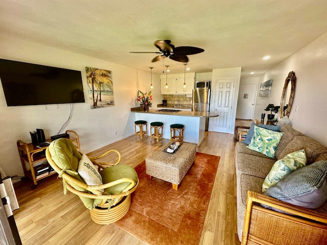 living room with ceiling fan and light hardwood / wood-style flooring