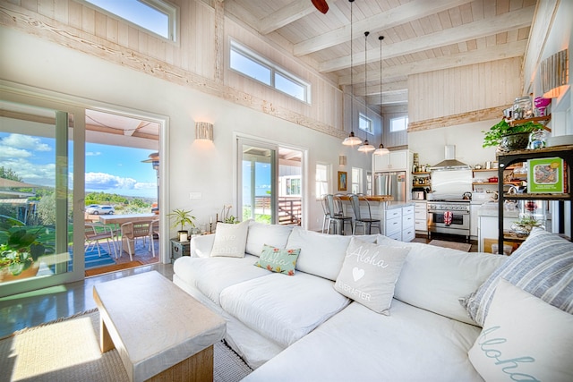 living room featuring wood ceiling, plenty of natural light, a high ceiling, and beamed ceiling