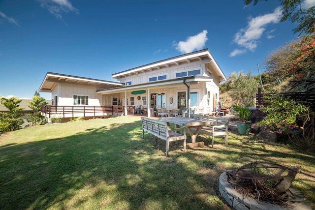 rear view of house featuring a yard and an outdoor fire pit