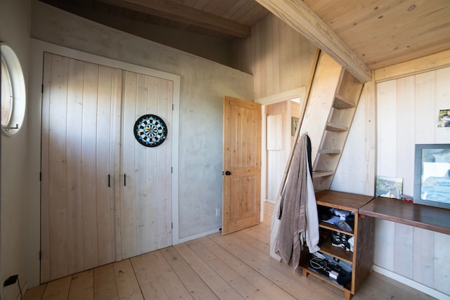 interior space featuring beamed ceiling, hardwood / wood-style flooring, wood ceiling, and wood walls