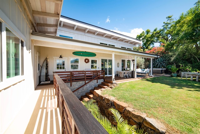 rear view of house with ceiling fan, a patio, and a lawn