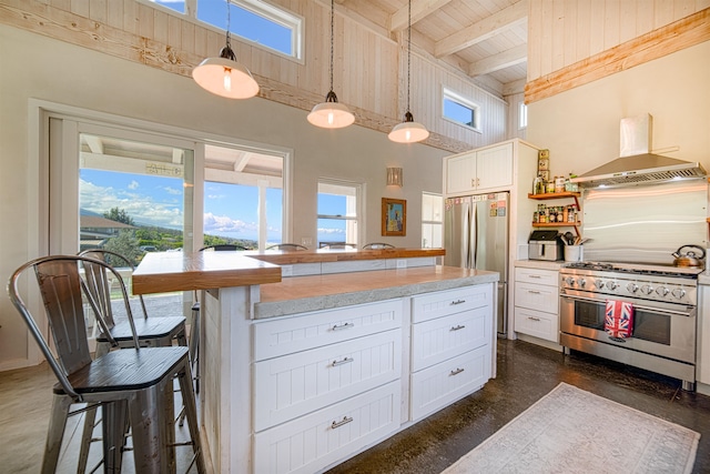 kitchen with stainless steel appliances, white cabinets, decorative light fixtures, and beam ceiling