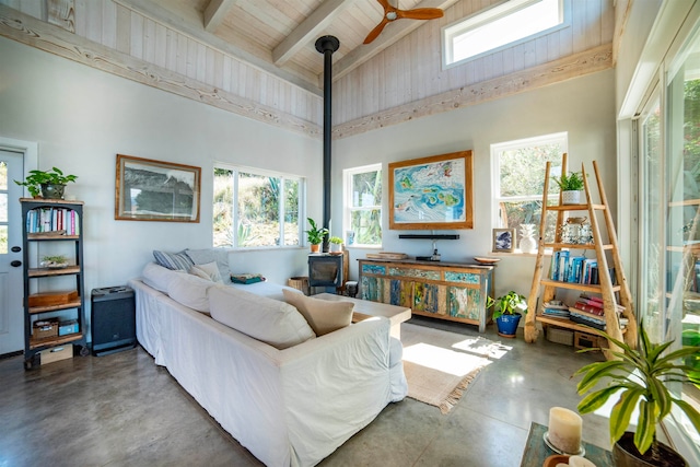 living room featuring high vaulted ceiling, beam ceiling, a healthy amount of sunlight, and concrete floors