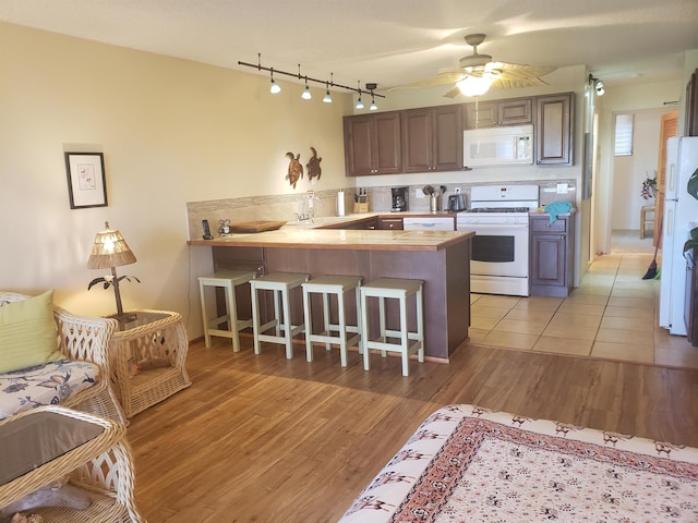 kitchen with ceiling fan, white appliances, light tile floors, kitchen peninsula, and rail lighting