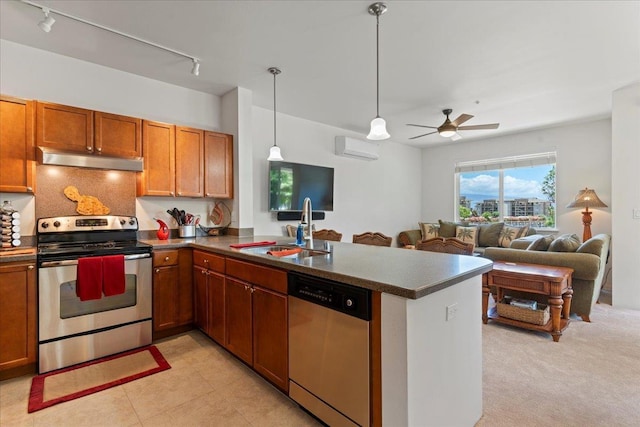 kitchen with stainless steel appliances, sink, hanging light fixtures, kitchen peninsula, and a wall unit AC