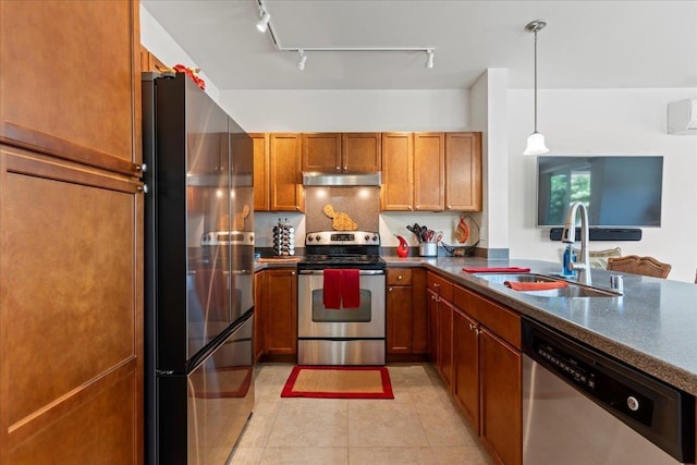 kitchen with pendant lighting, appliances with stainless steel finishes, sink, backsplash, and light tile patterned flooring