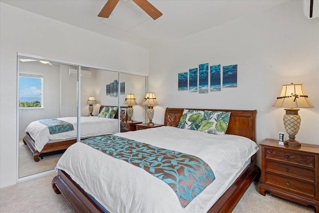 carpeted bedroom with a closet, ceiling fan, and a wall unit AC