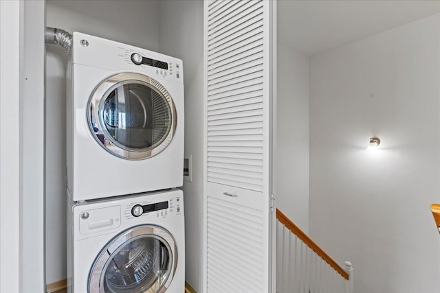 clothes washing area with stacked washer / dryer