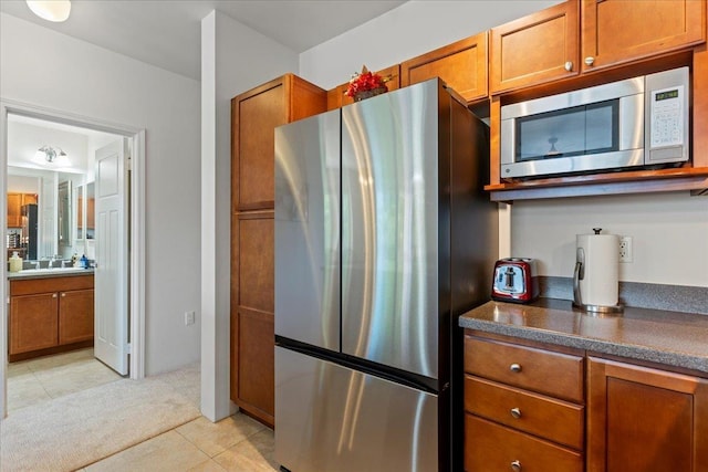 kitchen with sink, light colored carpet, and stainless steel appliances