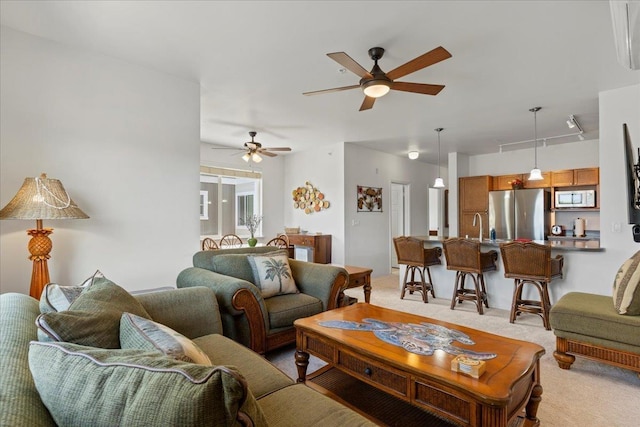 carpeted living room featuring sink and ceiling fan