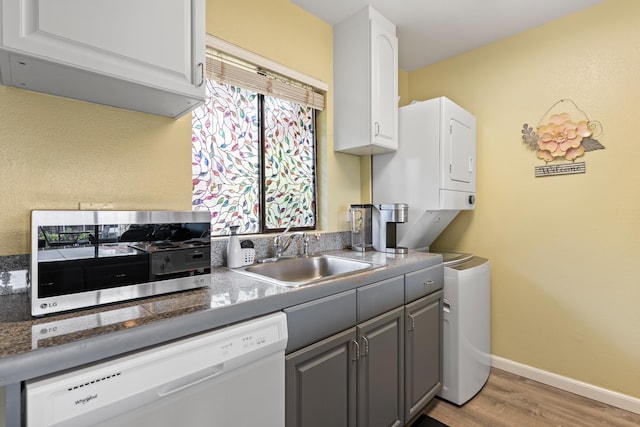 2219 S Kihei Rd Unit B312, Kihei, HI 96753 - kitchen with white dishwasher, stacked washer / drying machine, a sink, light wood finished floors, and gray cabinets
