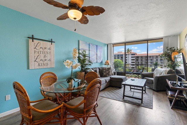 2219 S Kihei Rd Unit B312, Kihei, HI 96753 - dining area with a textured ceiling, wood finished floors, a ceiling fan, floor to ceiling windows, and baseboards