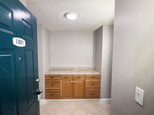 bathroom with tile patterned flooring, vanity, and a textured ceiling