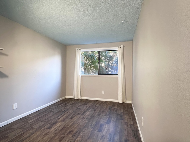 spare room with dark hardwood / wood-style flooring and a textured ceiling