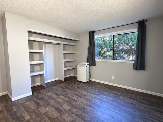 unfurnished bedroom with a textured ceiling and dark hardwood / wood-style floors