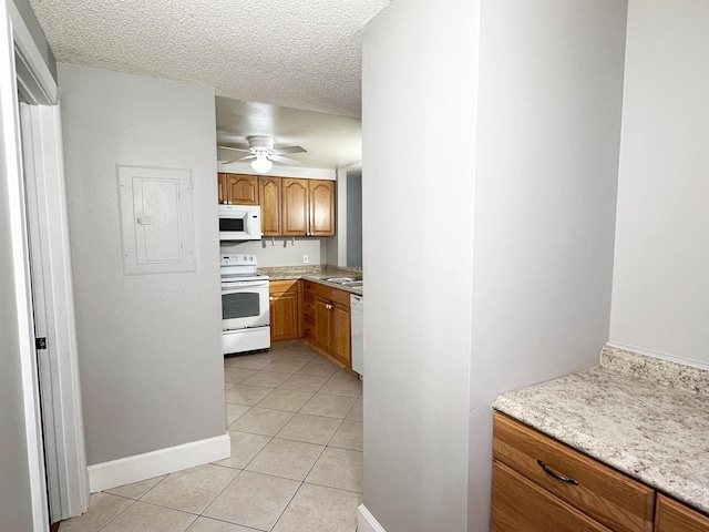 kitchen featuring ceiling fan, sink, a textured ceiling, white appliances, and light tile patterned floors