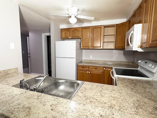 kitchen with white appliances, sink, ceiling fan, a textured ceiling, and kitchen peninsula