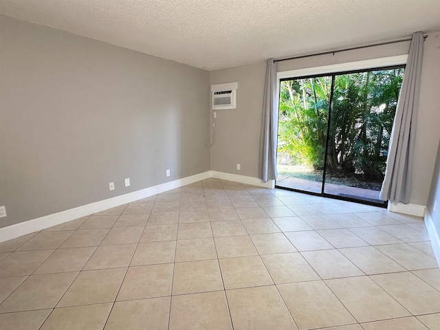 tiled empty room with a textured ceiling and an AC wall unit