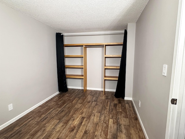 unfurnished bedroom with a closet, dark wood-type flooring, and a textured ceiling