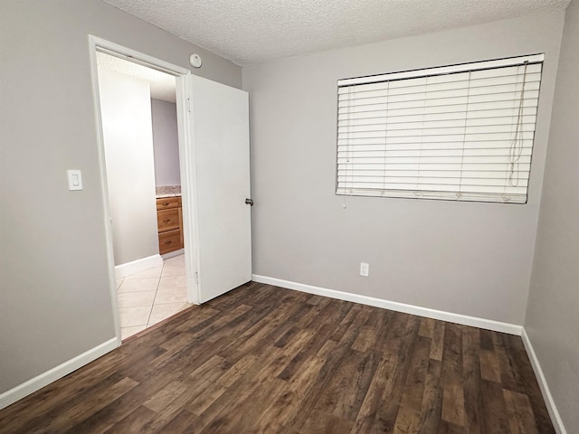 spare room with dark hardwood / wood-style flooring and a textured ceiling