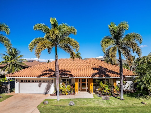 mediterranean / spanish-style house featuring a garage and a front lawn