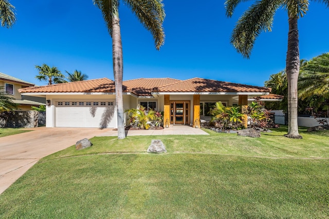 mediterranean / spanish house featuring a garage and a front yard