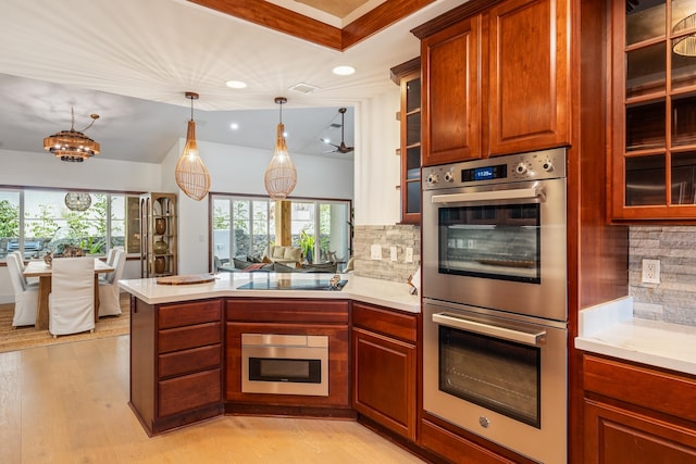 kitchen with backsplash, kitchen peninsula, decorative light fixtures, appliances with stainless steel finishes, and light wood-type flooring