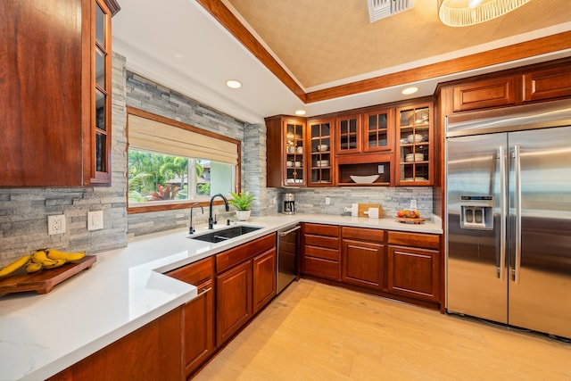 kitchen featuring crown molding, sink, light hardwood / wood-style flooring, appliances with stainless steel finishes, and tasteful backsplash