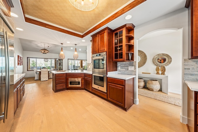 kitchen with a raised ceiling, tasteful backsplash, and hanging light fixtures