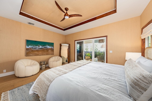 bedroom with access to outside, multiple windows, ceiling fan, and hardwood / wood-style flooring