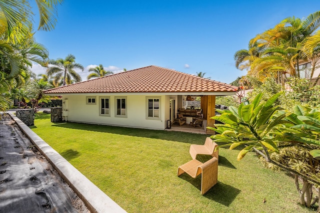 back of property featuring a lawn and a patio area