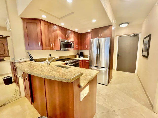 kitchen with sink, light stone counters, light tile patterned floors, kitchen peninsula, and appliances with stainless steel finishes