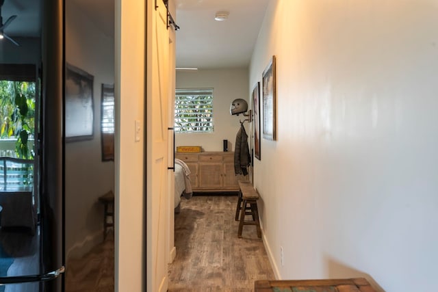 hall with a barn door and hardwood / wood-style floors