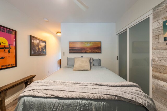 bedroom featuring ceiling fan, a closet, and hardwood / wood-style flooring