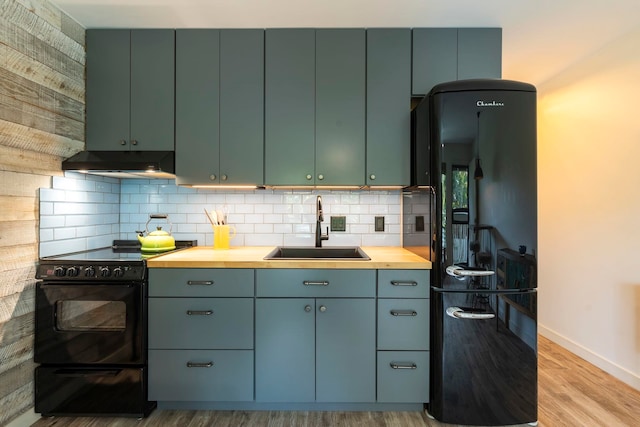 kitchen featuring decorative backsplash, sink, black appliances, and light hardwood / wood-style flooring