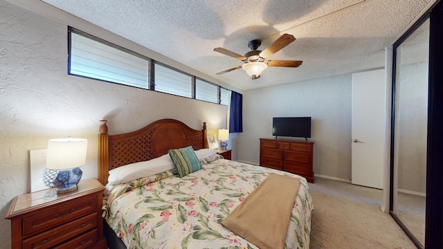 bedroom with a textured ceiling, light colored carpet, and ceiling fan