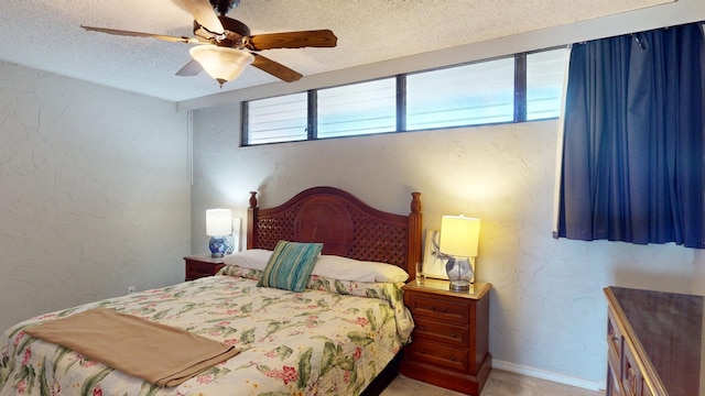 carpeted bedroom featuring ceiling fan and a textured ceiling