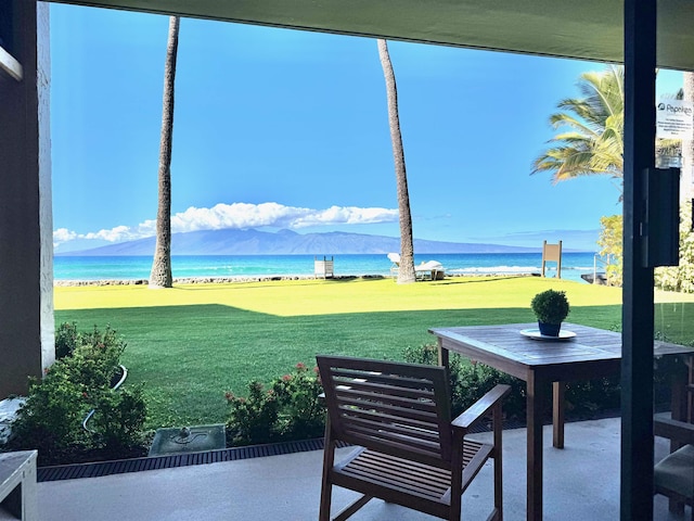 exterior space with a lawn and a water and mountain view