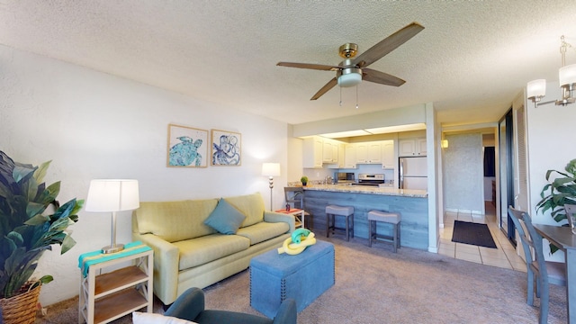 carpeted living room featuring ceiling fan and a textured ceiling