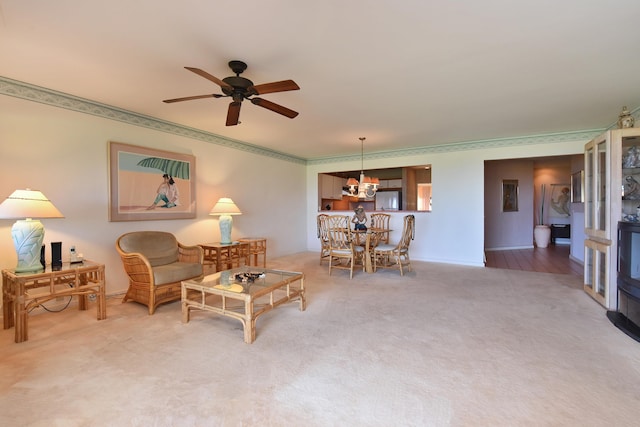 living room featuring carpet floors and ceiling fan with notable chandelier