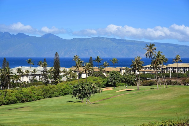 view of home's community with a water and mountain view and a yard