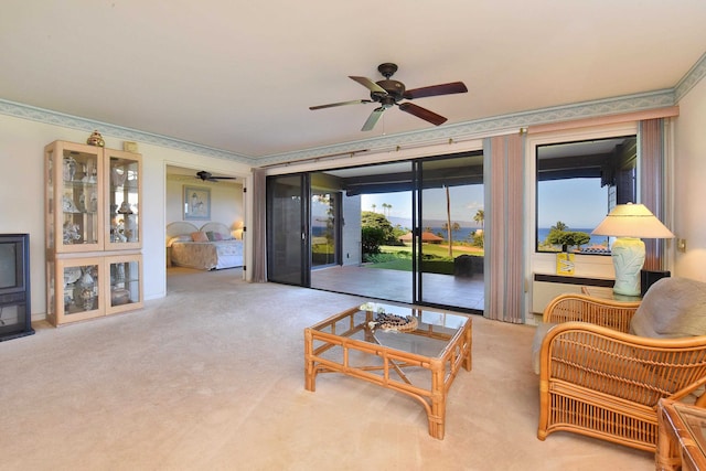 carpeted living room featuring ornamental molding, ceiling fan, and plenty of natural light